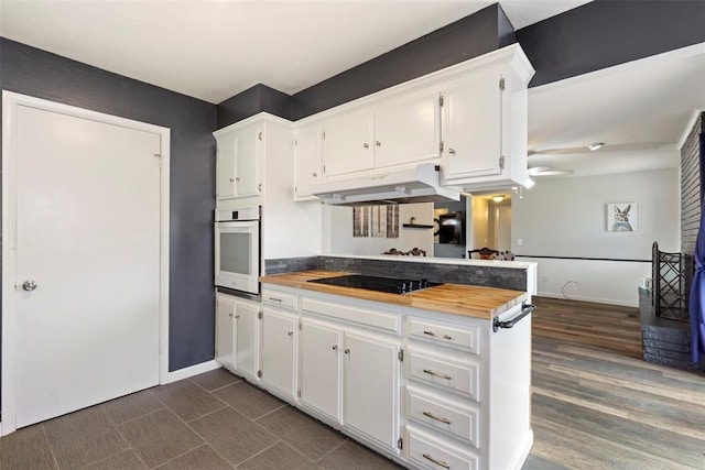 8316 NW 39th St, Bethany, OK 73008 - kitchen featuring under cabinet range hood, white oven, black electric stovetop, and white cabinets