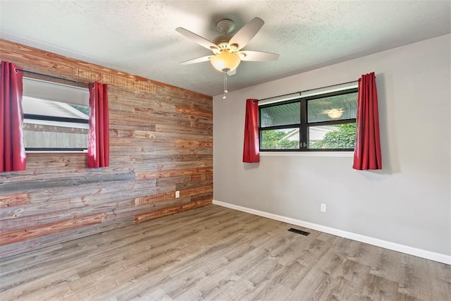 8316 NW 39th St, Bethany, OK 73008 - spare room with wood walls, ceiling fan, wood finished floors, and a textured ceiling