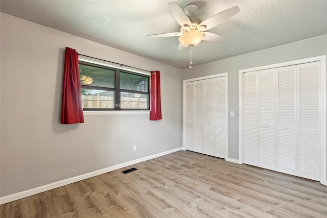 8316 NW 39th St, Bethany, OK 73008 - unfurnished bedroom with multiple closets, wood finished floors, a textured ceiling, and ceiling fan