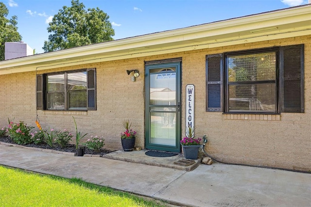213 Meadowlark Ln, Fort Cobb, OK 73038 - view of exterior entry featuring brick siding and a chimney