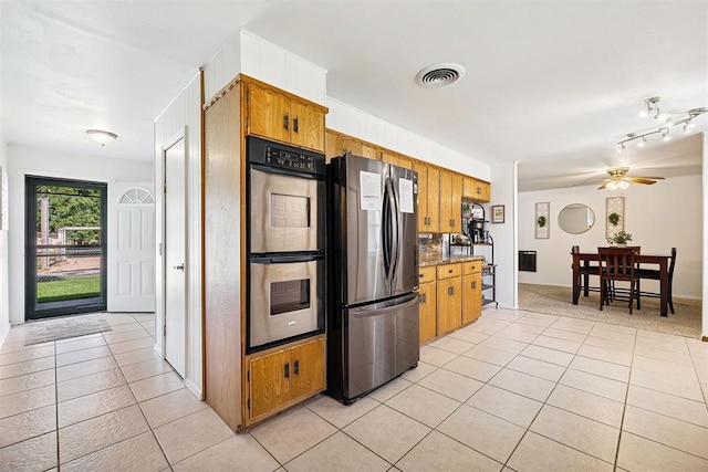 213 Meadowlark Ln, Fort Cobb, OK 73038 - kitchen with appliances with stainless steel finishes, light tile patterned floors, brown cabinets, and a ceiling fan