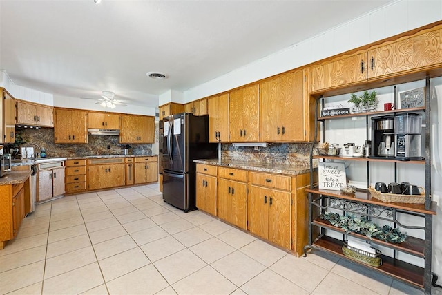 213 Meadowlark Ln, Fort Cobb, OK 73038 - kitchen with fridge with ice dispenser, brown cabinetry, and decorative backsplash