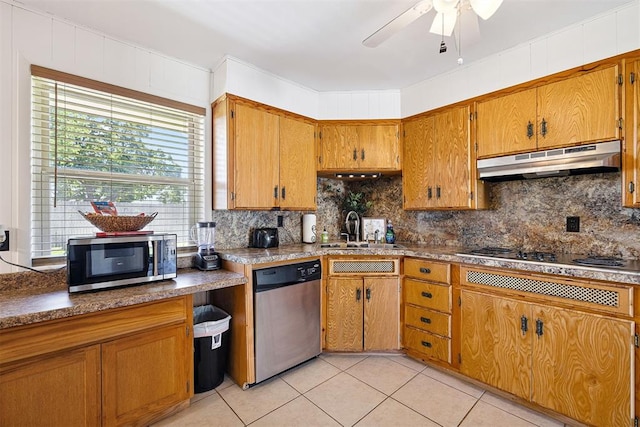 213 Meadowlark Ln, Fort Cobb, OK 73038 - kitchen featuring appliances with stainless steel finishes, under cabinet range hood, brown cabinetry, light tile patterned flooring, and ceiling fan
