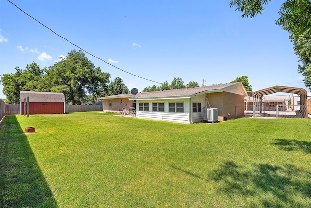 213 Meadowlark Ln, Fort Cobb, OK 73038 - rear view of house featuring a fenced backyard, a storage unit, and a detached carport