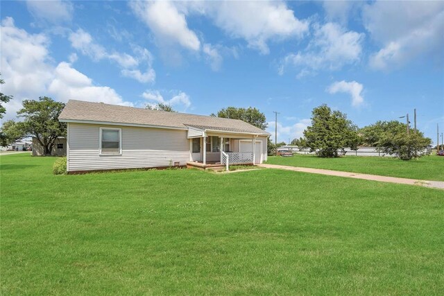 105 E E Walk, Canute, OK 73626 - view of front of house featuring driveway, an attached garage, and a front lawn