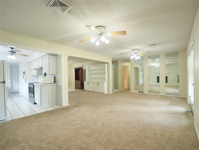 516 SW 63rd Ter, Oklahoma City, OK 73139 - unfurnished living room with a ceiling fan, light carpet, a textured ceiling, and light tile patterned floors