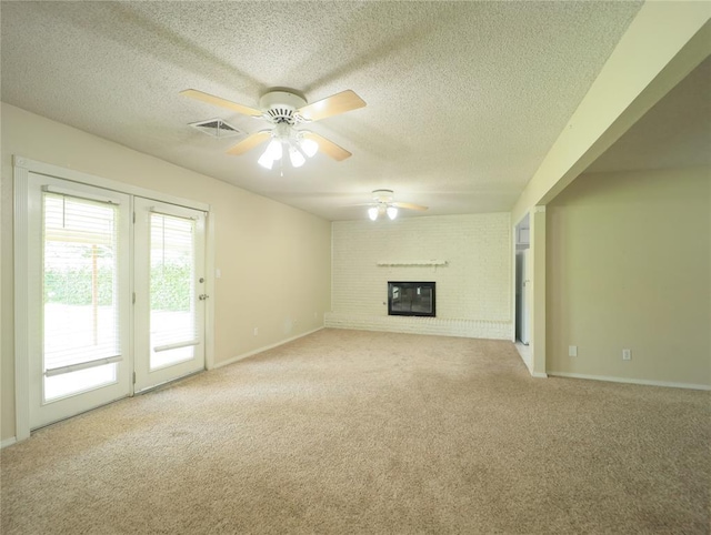 516 SW 63rd Ter, Oklahoma City, OK 73139 - unfurnished living room featuring ceiling fan, light carpet, a textured ceiling, and a brick fireplace
