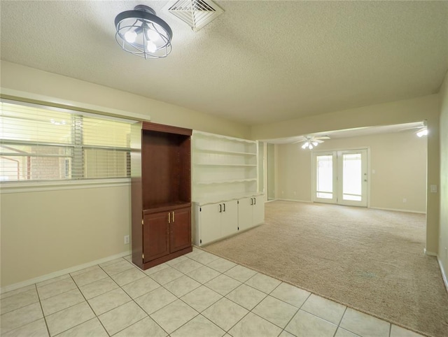 516 SW 63rd Ter, Oklahoma City, OK 73139 - unfurnished room with ceiling fan, a textured ceiling, light colored carpet, and light tile patterned floors