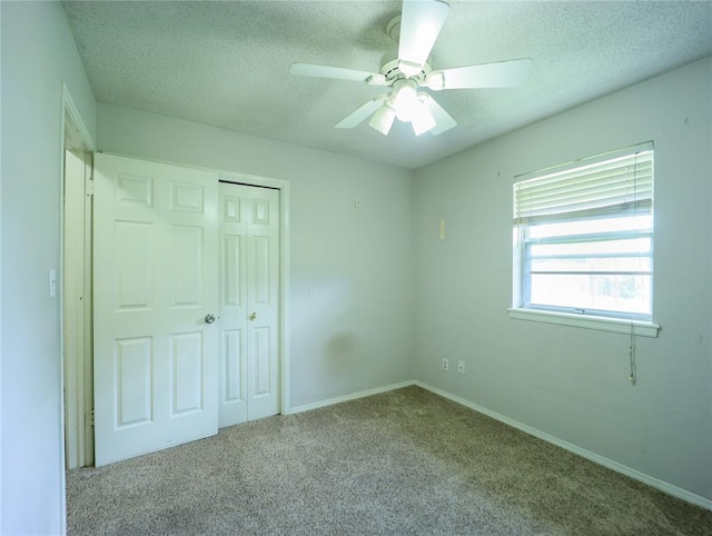 516 SW 63rd Ter, Oklahoma City, OK 73139 - unfurnished bedroom featuring a closet, a textured ceiling, carpet floors, and a ceiling fan