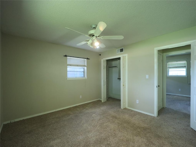 516 SW 63rd Ter, Oklahoma City, OK 73139 - unfurnished bedroom with multiple windows, a textured ceiling, a closet, carpet floors, and ceiling fan