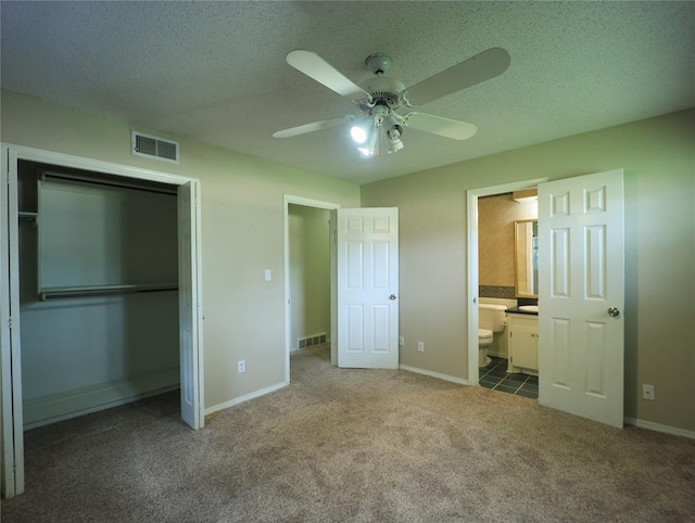 516 SW 63rd Ter, Oklahoma City, OK 73139 - unfurnished bedroom featuring carpet floors, a closet, a textured ceiling, ensuite bath, and a ceiling fan