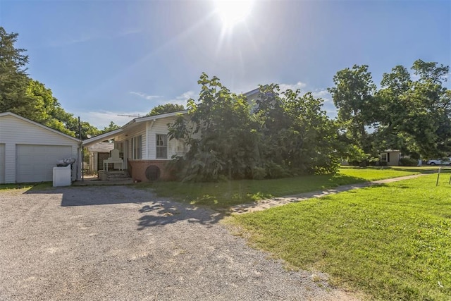 400 E Wagner Ave, Pauls Valley, OK 73075 - view of front of home with a front yard, brick siding, an outdoor structure, gravel driveway, and a detached garage