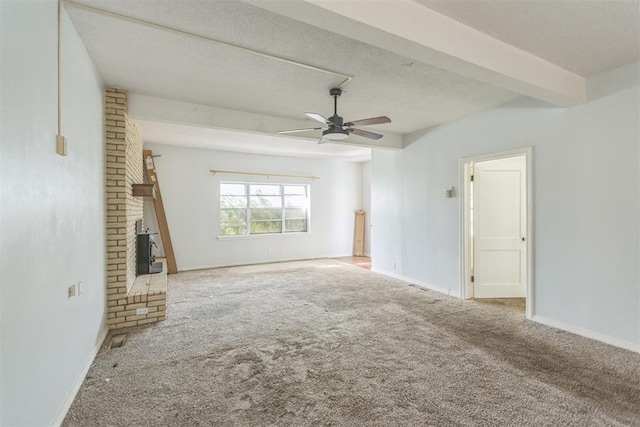 400 E Wagner Ave, Pauls Valley, OK 73075 - unfurnished living room featuring carpet, ceiling fan, a textured ceiling, and a fireplace