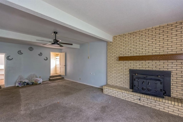 400 E Wagner Ave, Pauls Valley, OK 73075 - unfurnished living room featuring a wood stove, a ceiling fan, carpet, beamed ceiling, and a textured ceiling