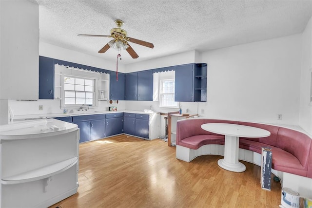 400 E Wagner Ave, Pauls Valley, OK 73075 - kitchen with open shelves, blue cabinets, ceiling fan, plenty of natural light, and a textured ceiling