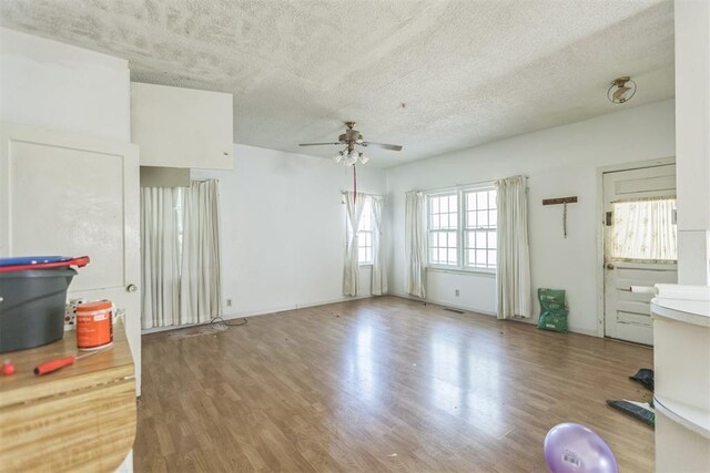 400 E Wagner Ave, Pauls Valley, OK 73075 - unfurnished living room featuring a ceiling fan, wood finished floors, and a textured ceiling