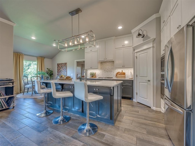 4116 Armstead Ave, Edmond, OK 73012 - kitchen featuring stainless steel appliances, light countertops, backsplash, a kitchen breakfast bar, and an island with sink