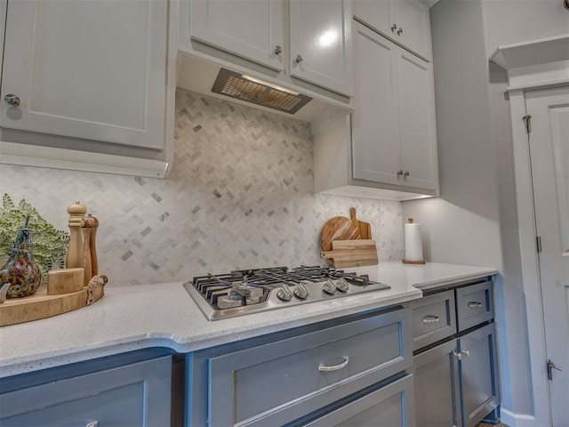 4116 Armstead Ave, Edmond, OK 73012 - kitchen featuring stainless steel gas cooktop, decorative backsplash, light stone counters, and under cabinet range hood