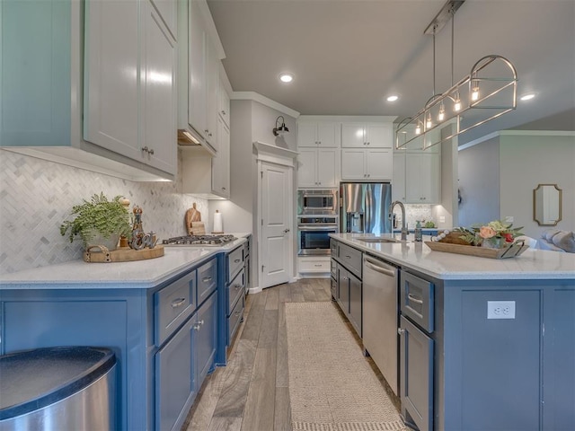 4116 Armstead Ave, Edmond, OK 73012 - kitchen with blue cabinets, appliances with stainless steel finishes, light countertops, light wood-type flooring, and recessed lighting