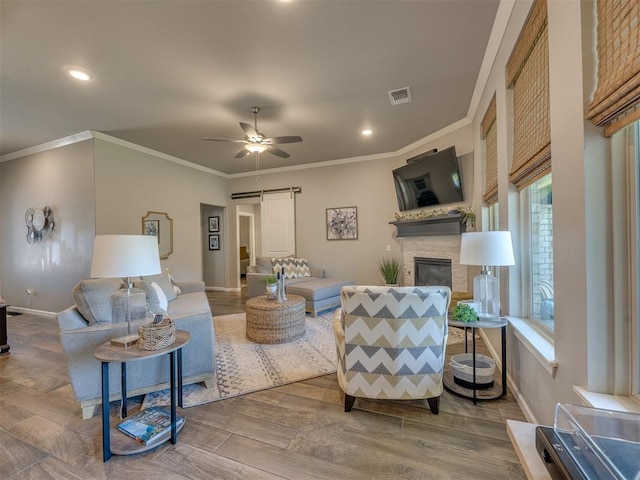 4116 Armstead Ave, Edmond, OK 73012 - living area featuring ornamental molding, a ceiling fan, a stone fireplace, wood finished floors, and recessed lighting