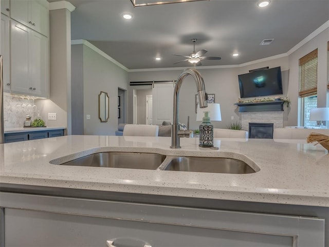 4116 Armstead Ave, Edmond, OK 73012 - kitchen with open floor plan, light stone countertops, recessed lighting, crown molding, and a fireplace
