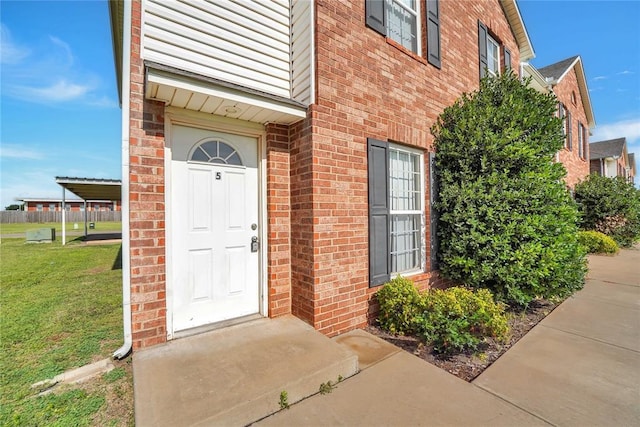 1501 N Wade St, Sayre, OK 73662 - doorway to property featuring brick siding and a lawn