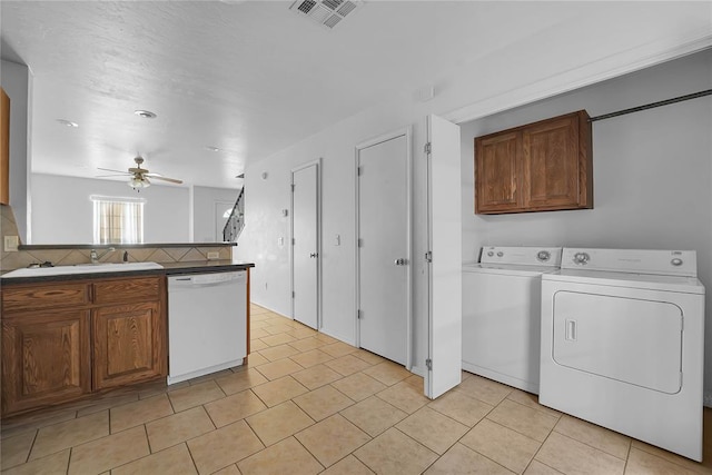 1501 N Wade St, Sayre, OK 73662 - kitchen featuring white dishwasher, washing machine and dryer, ceiling fan, tasteful backsplash, and light tile patterned floors
