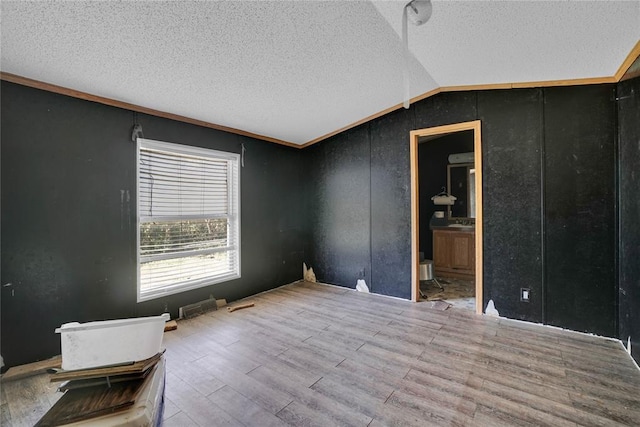 11567 N 1790th Rd, Sayre, OK 73662 - empty room featuring a textured ceiling, vaulted ceiling, and wood finished floors