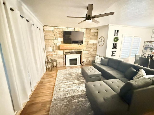 717 E Walnut St, Altus, OK 73521 - living area featuring a ceiling fan, wood finished floors, a stone fireplace, and ornamental molding