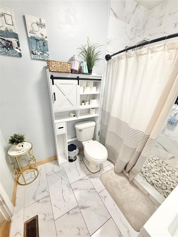 717 E Walnut St, Altus, OK 73521 - full bath with marble look tiles and curtained shower