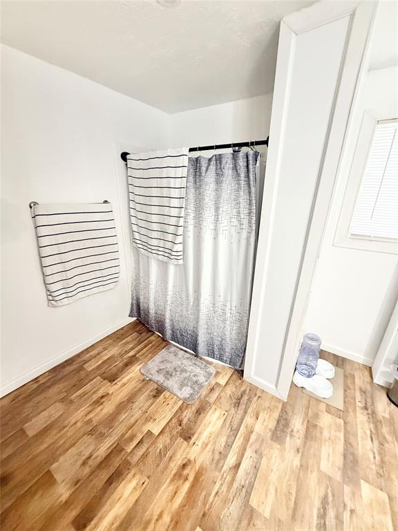 717 E Walnut St, Altus, OK 73521 - unfurnished bedroom with wood finished floors