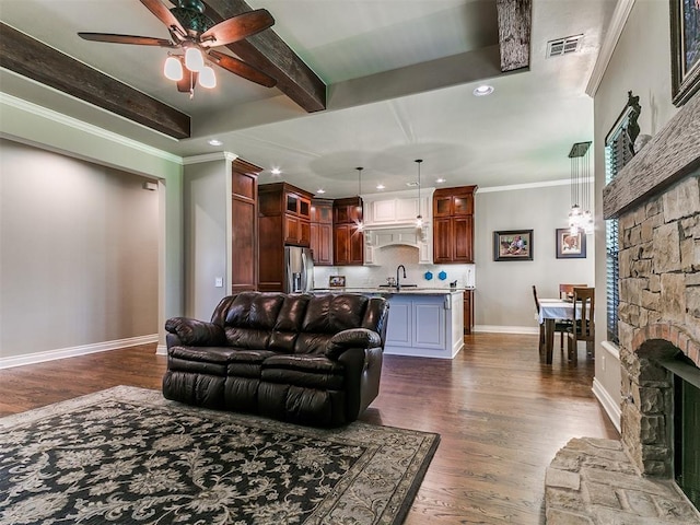 12105 SW 45th Ter, Mustang, OK 73064 - living area featuring a ceiling fan, recessed lighting, dark wood-style flooring, a fireplace, and beamed ceiling