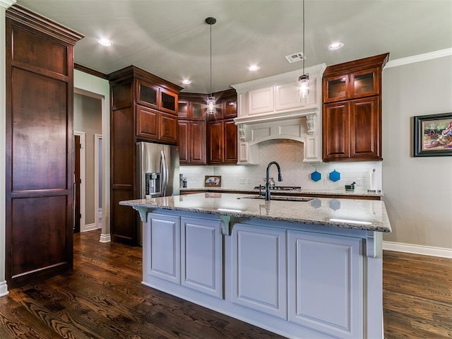 12105 SW 45th Ter, Mustang, OK 73064 - kitchen with dark wood finished floors, backsplash, light stone countertops, a kitchen island with sink, and glass insert cabinets