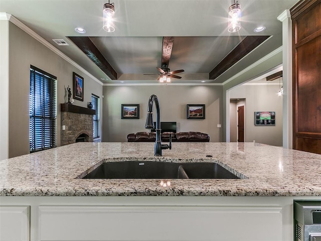 12105 SW 45th Ter, Mustang, OK 73064 - kitchen with open floor plan, crown molding, light stone countertops, a tray ceiling, and a ceiling fan