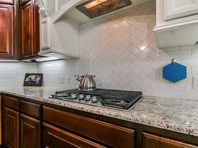 12105 SW 45th Ter, Mustang, OK 73064 - kitchen featuring stainless steel gas stovetop, decorative backsplash, and light stone counters