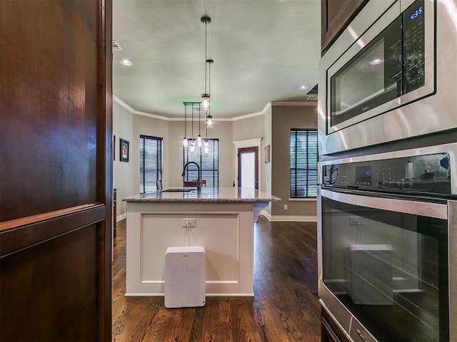 12105 SW 45th Ter, Mustang, OK 73064 - kitchen featuring appliances with stainless steel finishes, crown molding, dark wood-type flooring, light stone countertops, and pendant lighting