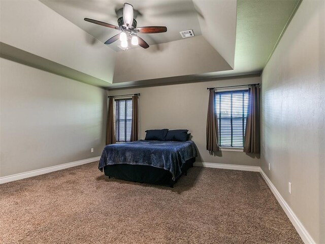 12105 SW 45th Ter, Mustang, OK 73064 - carpeted bedroom with a raised ceiling and a ceiling fan