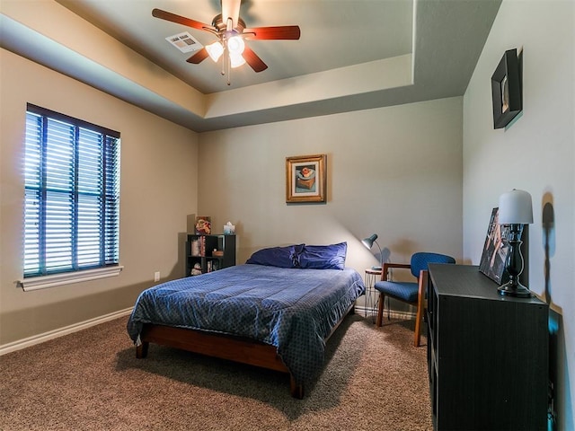 12105 SW 45th Ter, Mustang, OK 73064 - carpeted bedroom with a tray ceiling and a ceiling fan