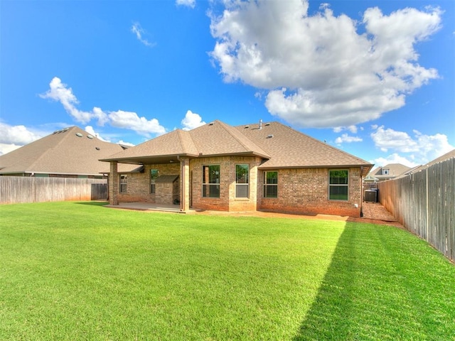 12105 SW 45th Ter, Mustang, OK 73064 - rear view of house with a patio area, brick siding, a shingled roof, and a fenced backyard