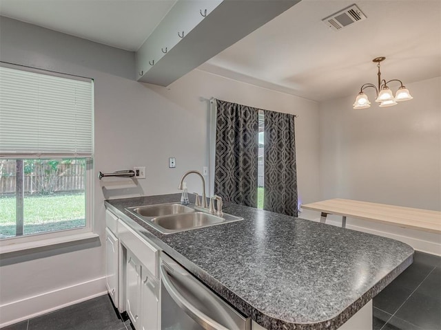 1713 SE 14th St, Moore, OK 73160 - kitchen with dishwasher, dark countertops, white cabinets, dark tile patterned floors, and a chandelier