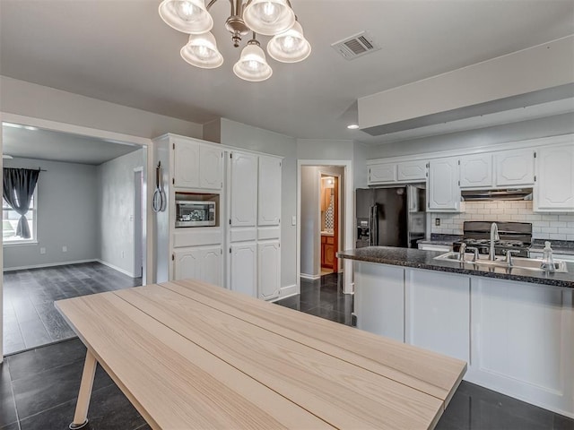 1713 SE 14th St, Moore, OK 73160 - kitchen featuring black refrigerator with ice dispenser, white cabinets, stainless steel microwave, and a chandelier