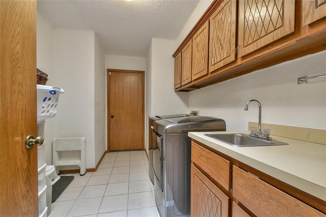 3121 SW 128th St, Oklahoma City, OK 73170 - laundry room with washer and clothes dryer, cabinet space, light tile patterned floors, and a textured ceiling