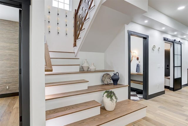 1432 NE Euclid St, Oklahoma City, OK 73117 - stairway featuring wood finished floors, a barn door, and recessed lighting