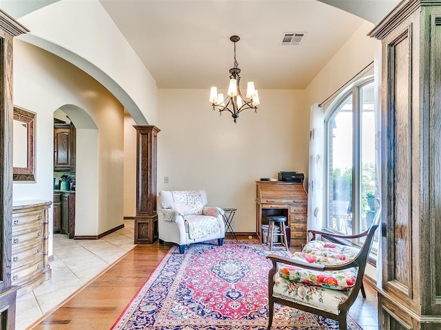 73 Sonata Ln, Shawnee, OK 74804 - living area featuring arched walkways, a chandelier, and light wood-style flooring