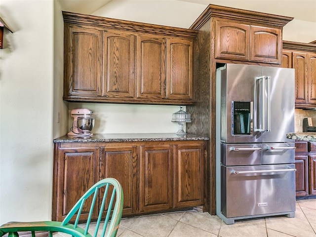 73 Sonata Ln, Shawnee, OK 74804 - kitchen featuring high end refrigerator, light tile patterned flooring, and dark stone countertops