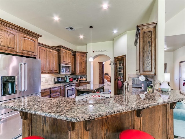 73 Sonata Ln, Shawnee, OK 74804 - kitchen with appliances with stainless steel finishes, arched walkways, a peninsula, a kitchen breakfast bar, and recessed lighting