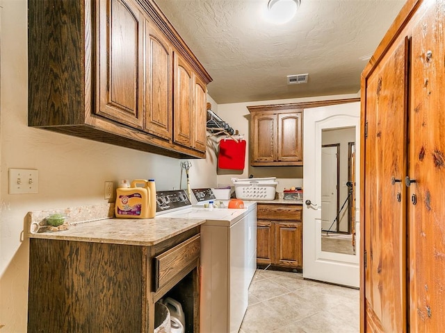 73 Sonata Ln, Shawnee, OK 74804 - washroom featuring cabinet space, washing machine and clothes dryer, light tile patterned flooring, and a textured ceiling