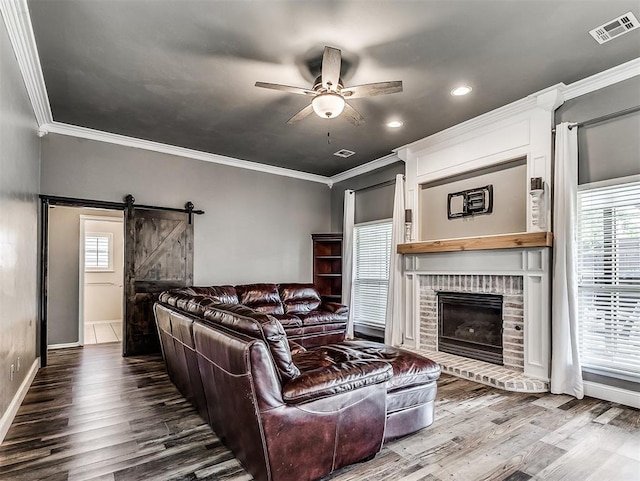 2044 Yorkshire Dr, Midwest City, OK 73130 - living area with a ceiling fan, wood finished floors, crown molding, a brick fireplace, and a barn door