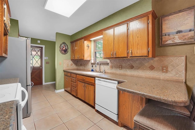22117 E 1250th Rd, Rocky, OK 73661 - kitchen with dishwasher, brown cabinets, and decorative backsplash