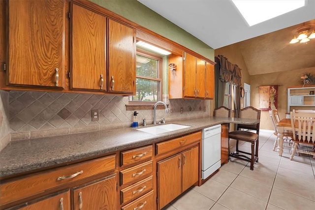 22117 E 1250th Rd, Rocky, OK 73661 - kitchen featuring white dishwasher, brown cabinetry, backsplash, light tile patterned floors, and lofted ceiling